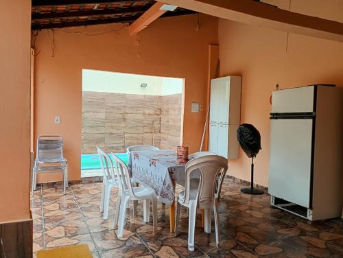 a dining room with a table and chairs and a refrigerator at Casa Mosqueiro in Belém
