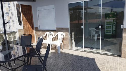 two white plastic chairs sitting on a patio at Apto Perequê Sacada Frente in Porto Belo