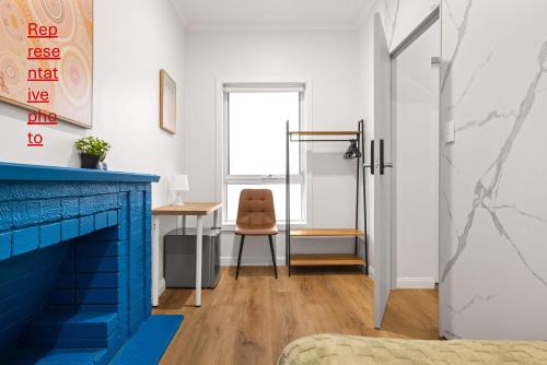 una habitación con una chimenea azul y una silla en Inviting Single Room with Sunlit Comfort - Matraville - Shared Bathroom and Kitchen, en Sídney