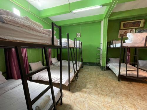 een groep stapelbedden in een kamer met groene muren bij DP Guest-house in Pakbeng