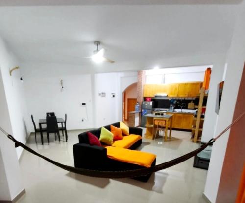 a living room with a couch and a hammock at Casa Colibri - Confort et Authentique, à 300m de la plage ! in Mindelo