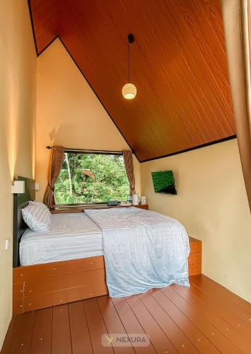 a bedroom with a large bed with a window at The Kotenang in Wonosobo