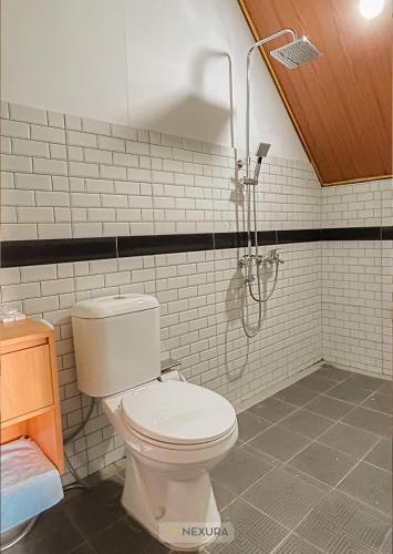 a bathroom with a toilet and a shower at The Kotenang in Wonosobo