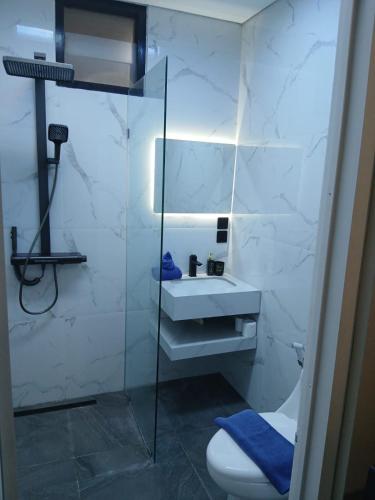 a bathroom with a glass shower and a toilet at Kuta Regency B10 One Bedroom Villa in Kuta