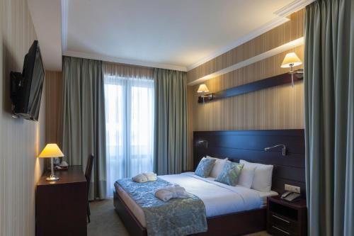 Una cama o camas en una habitación de Hotel Astoria Tbilisi