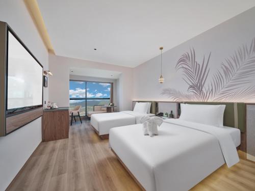 a hotel room with two beds and a television at Lijiang Gucheng District RIM Hotel in Lijiang