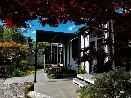 a screened in patio with a table and benches at Luxury Farm Escape Tiny Home New Plymouth-Egmont Village in Egmont Village