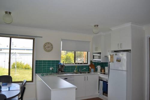 a kitchen with white cabinets and a clock on the wall at Lees171 in Evergreen