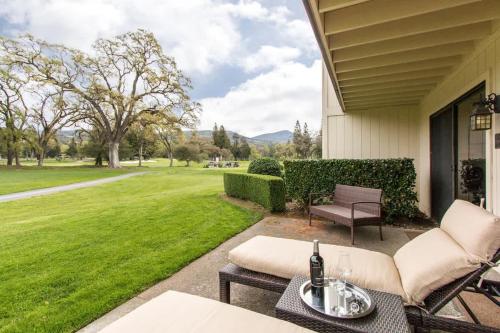 un patio con sillas, mesa y césped en Luxe Golf View Condo Prime Napa Location, en Vichy Springs