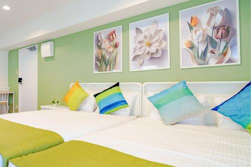 a bedroom with a large white bed with colorful pillows at Higashi-Shinjuku 906 in Tokyo