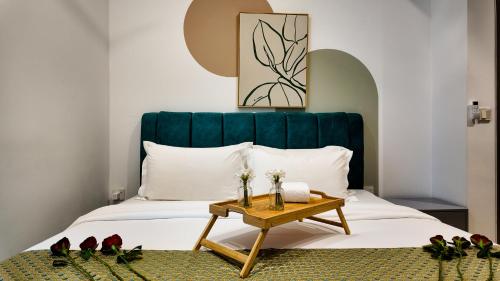 a bedroom with a bed with a blue headboard and a table at Eaton Residence Kuala Lumpur - M Home in Kuala Lumpur