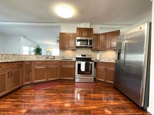 een keuken met houten kasten en roestvrijstalen apparatuur bij Cozy Home in Kissimmee