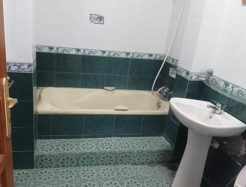 ein Badezimmer mit Waschbecken und Badewanne und Waschbecken in der Unterkunft Sentral Villa Trawas in Trawas