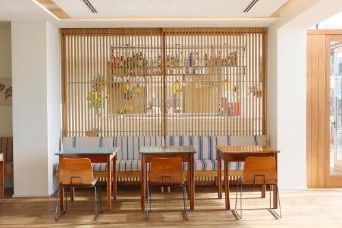 a dining room with two tables and chairs at Hostal Empúries in L'Escala