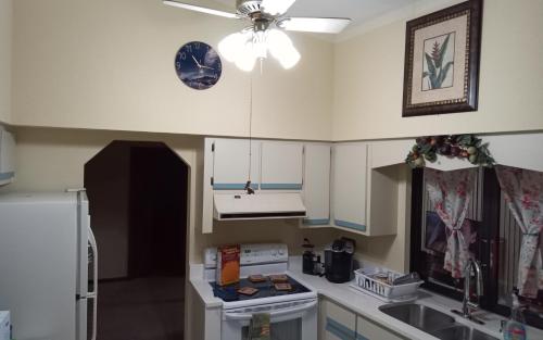 a kitchen with white cabinets and a clock on the ceiling at Prada Home Club in Punta Gorda