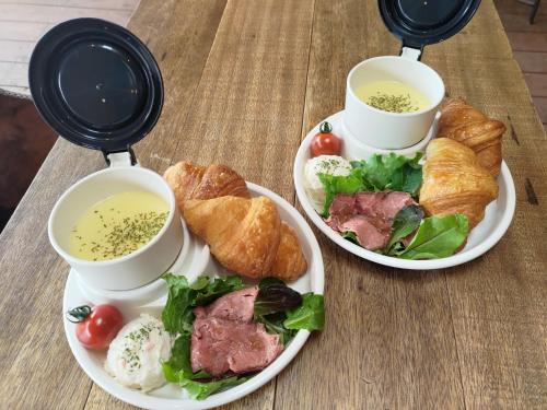 志摩市Kabuku Resort的桌子上放着两盘食物和两杯汤。