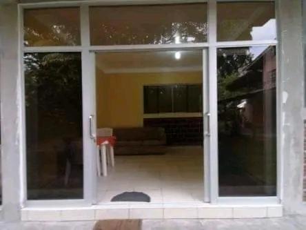 een grote glazen deur van een huis met een woonkamer bij Emerald forest apartment in Iquitos