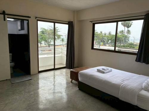 a bedroom with a bed and a large window at VS Beach Front in Jomtien Beach