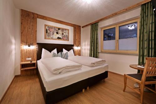 リート・イム・ツィラータールにあるLandhaus & Apartment Taxachのベッドルーム(大型ベッド1台、窓付)