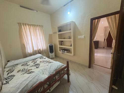 科钦Kochuthottathil Heritage的一间卧室设有一张床,门通往走廊