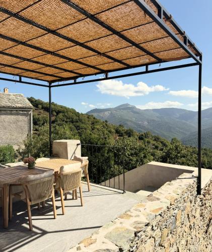 a patio with a table and chairs and a view at Village House With Character In Corsica in Scolca