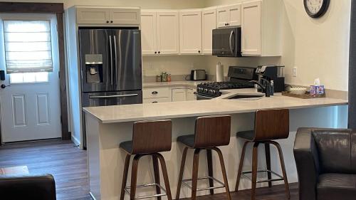 a kitchen with a counter and three bar stools at Tranquil Retreat in Bozeman