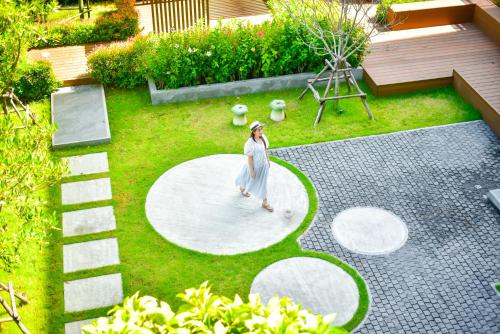 a woman walking on a circle in a garden at The Kite Hotel Bangsaen by Koko in Ban Laem Thaen