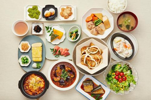a table with many different plates of food at Sotetsu Fresa Inn Kobe Sannomiya in Kobe