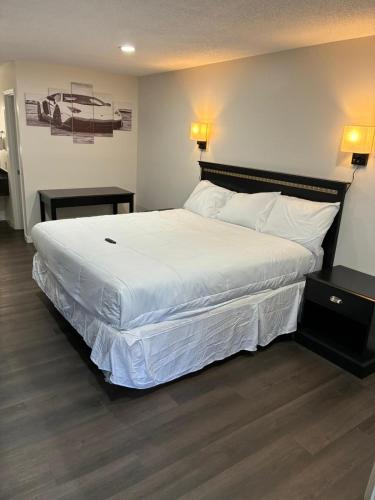 a bedroom with a large bed with white sheets at Suite Stay in Talladega