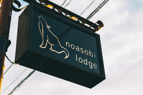 a sign for a mooseott lodge on a pole at のあそびlodge in Arao