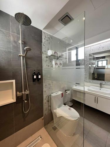 a bathroom with a shower and a toilet and a sink at Doña Manor Boutique Hotel in Olongapo