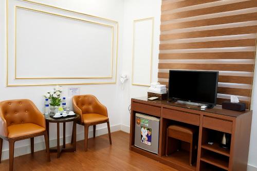 a living room with two chairs and a television at An Phú Hostel in Gia Lâm Pho