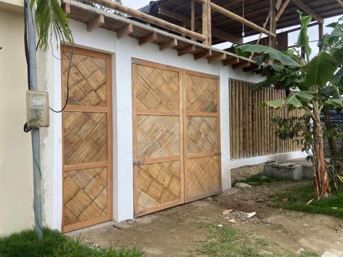 ein Paar Garagentüren aus Holz an einem Haus in der Unterkunft Villa en Salango con piscina in Salango