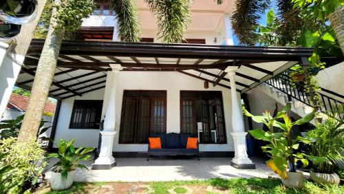 een huis met een stoel onder een pergola bij MobyDick House in Mirissa