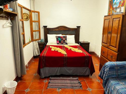 Un dormitorio con una cama con una manta roja. en Casa Altavista, en Antigua Guatemala