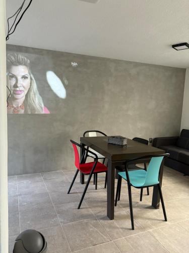 a dining room with a table and colorful chairs at Comoda casa para alojamiento in Veracruz