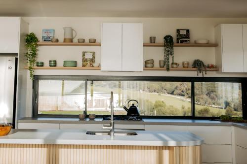 een keuken met een spoelbak en een raam bij Coast in Stokes Bay