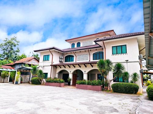 een groot wit huis met groene ramen bij Villa 223 in Kajang