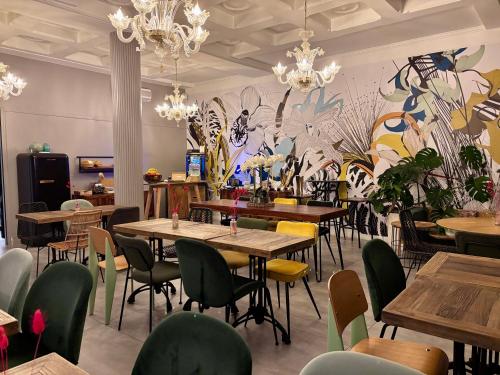 オルレアンにあるUrban Jungle Hôtel Orleansのテーブルと椅子と壁画のあるレストラン