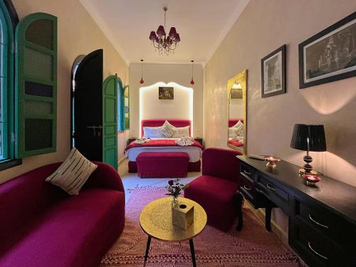 a bedroom with a bed and a couch and a table at Riad Lia ou Lik in Marrakesh