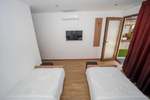 een kamer met twee bedden en een glazen schuifdeur bij Banya Guest Rooms 23 in Banya