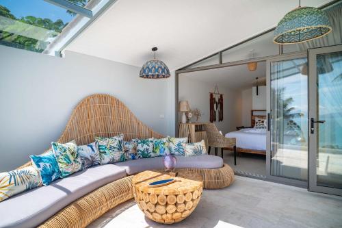 バーン・バンポーにある2br Tropical Villa Elisa Sea View Pool Breakfastのソファのあるリビングルームと寝室