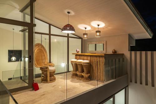 バーン・バンポーにある2br Tropical Villa Elisa Sea View Pool Breakfastの椅子とテーブルとガラスのある部屋