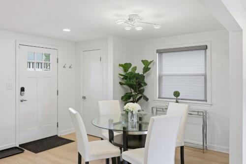 a dining room with a glass table and white chairs at Snyder Sanctuary Retreat home in Amherst