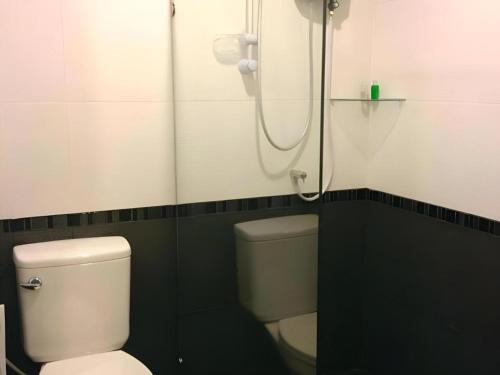 Un baño con inodoro blanco y ducha. en The Capital Hotel, en Roi Et