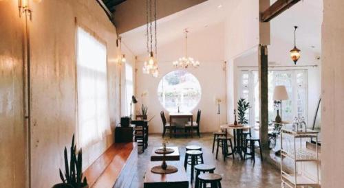 a large room with chairs and tables and aandelier at Khemjit cafe' and bed in Ban Kao