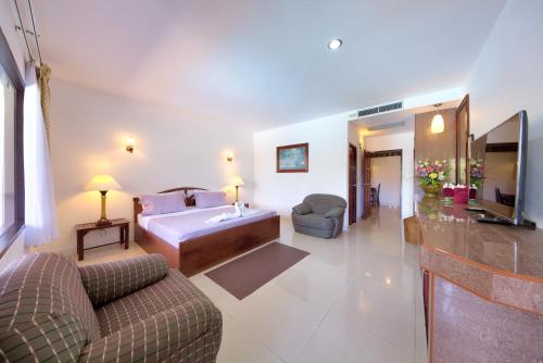 a living room with a couch and a bed and a television at Aumpai Luxury in Lamai