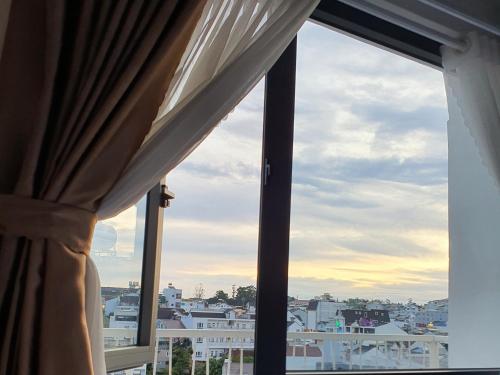 a window with a view of a city at Khách sạn Hoàng Khôi in Da Lat