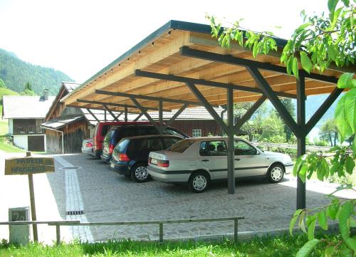 a parking lot with cars parked under a roof at Ferienhaus Knaller in Weissensee