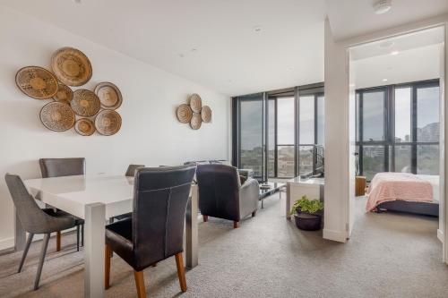 a dining room with a table and chairs and a bedroom at Executive Two bedroom & two bathrooms in Melbourne